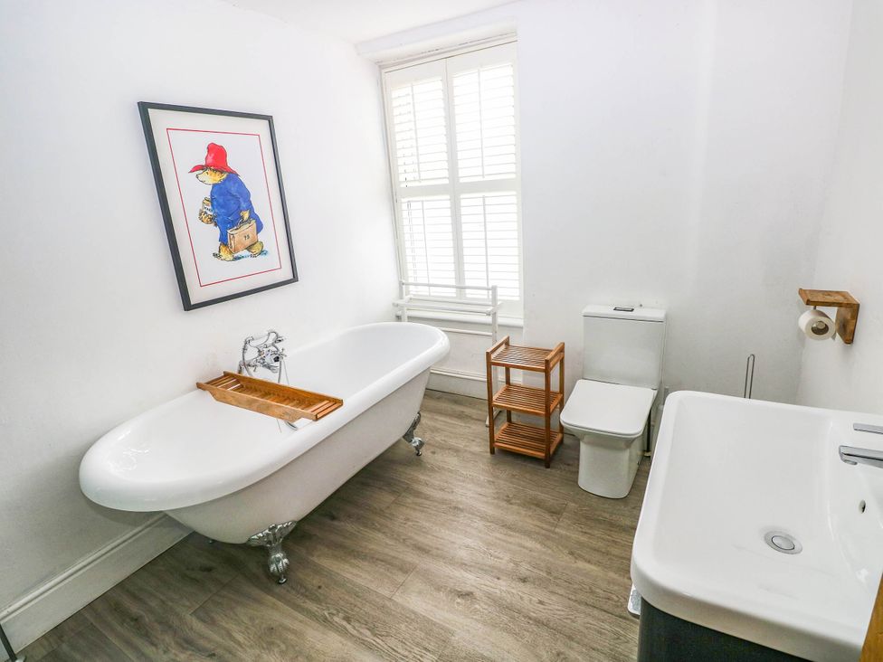 A bathroom with a bathtub, toilet, and sink at Y Glyn in Borth