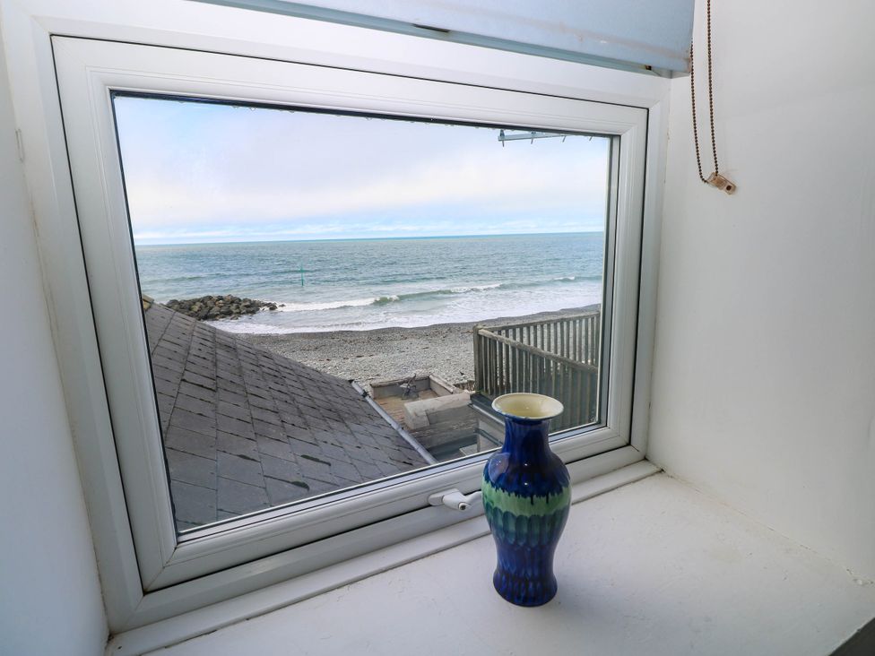 A window with a view of the sea and a vase at Y Glyn in Borth