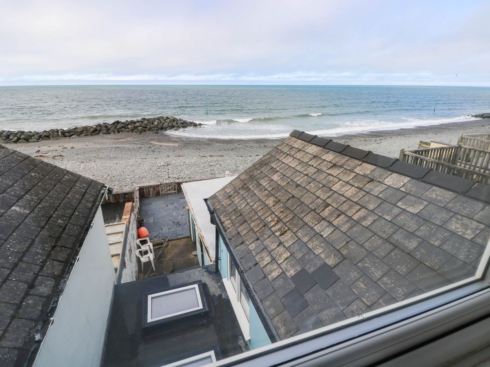 An outdoor view of a beach and sea from a property at Y Glyn in Borth