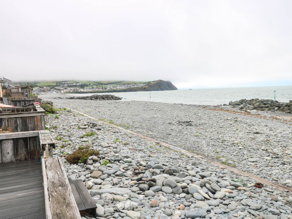 A beach with pebbles and a view of the sea at Y Glyn in Borth