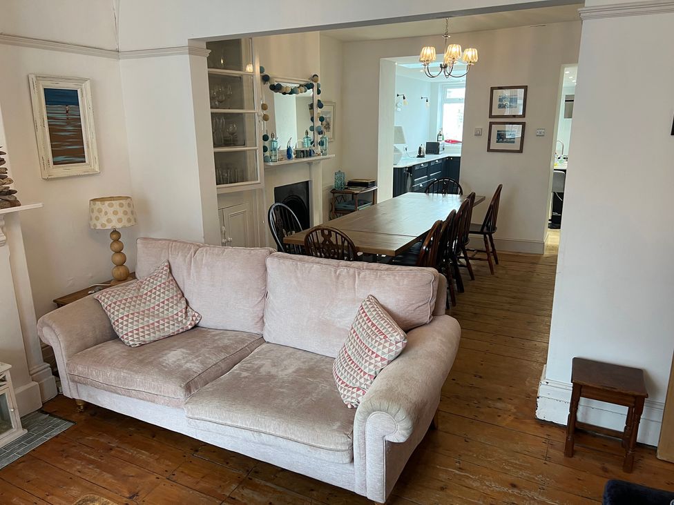 A living room with a sofa and dining area at Y Glyn in Borth