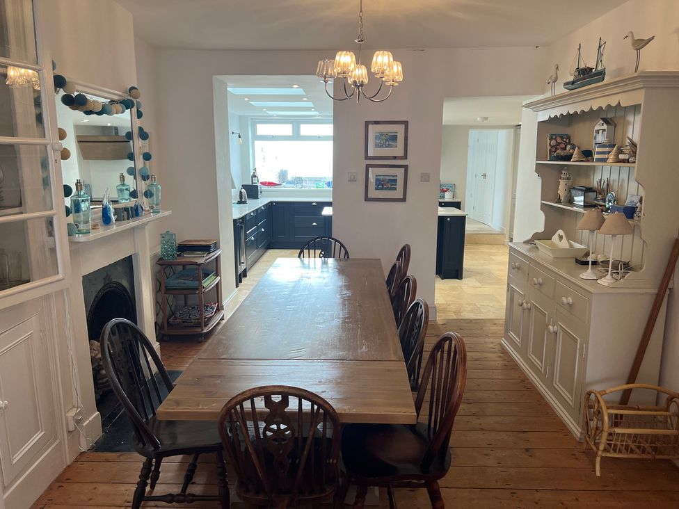 A dining room with a long table and chairs at Y Glyn Borth