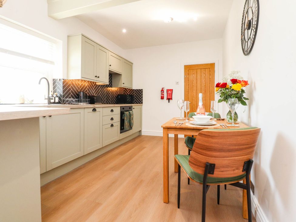 A kitchen with a dining table and chairs at The Swallows near Glasson
