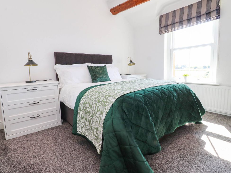 A bedroom with a bed and nightstand at The Swallows near Glasson