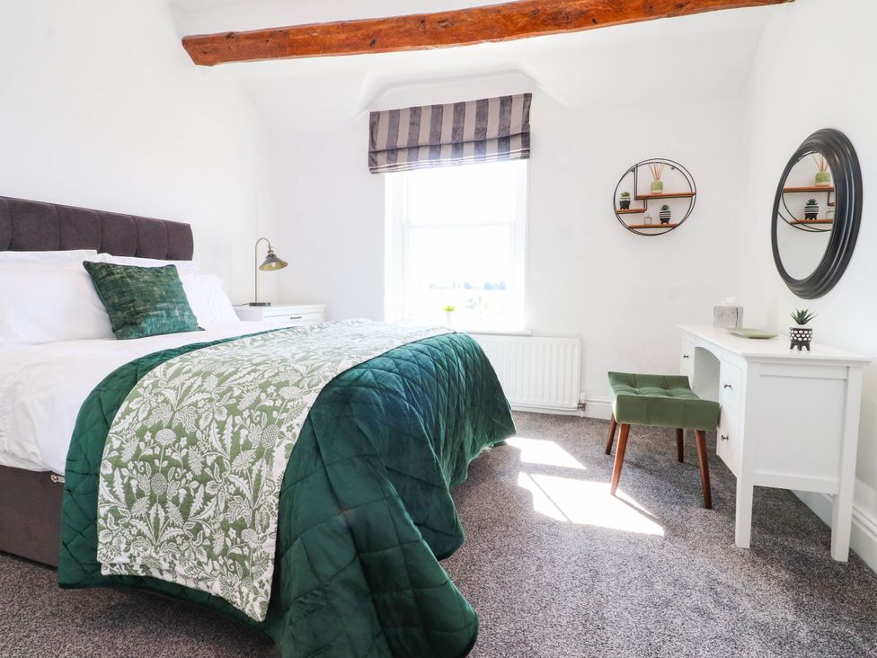 A bedroom with a bed and desk at The Swallows near Glasson