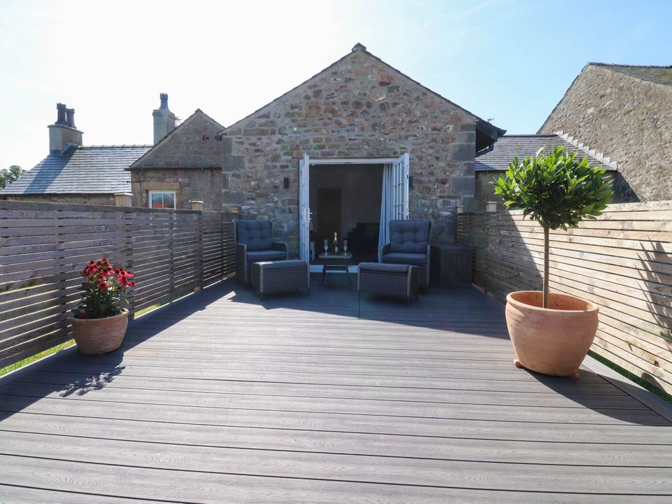 An outdoor patio with chairs and a table at The Swallows near Glasson