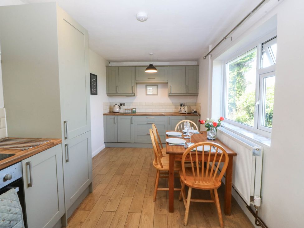 A kitchen with a dining table and chairs at Wilpol in Llanerchymedd