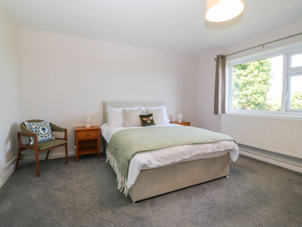 A bedroom with a bed and nightstand at Wilpol in Llanerchymedd