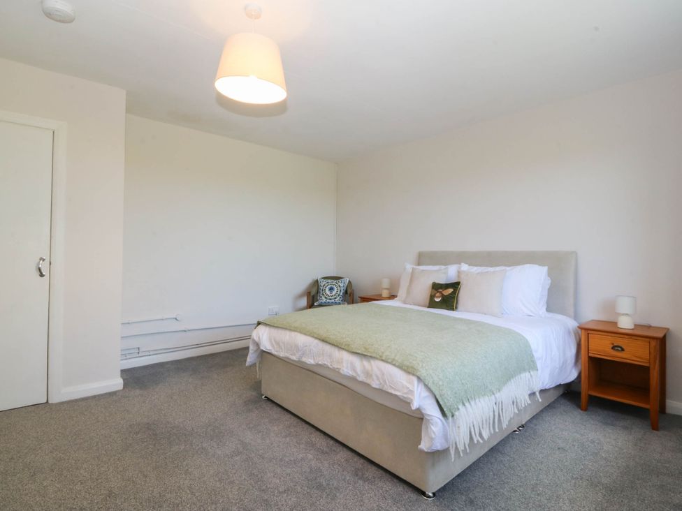A bedroom with a bed and nightstand at Wilpol in Llanerchymedd