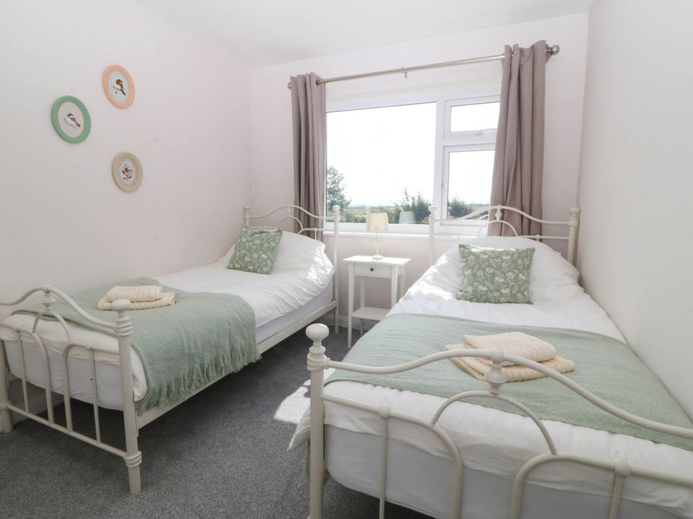 A bedroom with two beds and a window at Wilpol in Llanerchymedd