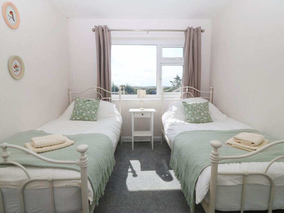 A bedroom with two beds and a window at Wilpol in Llanerchymedd