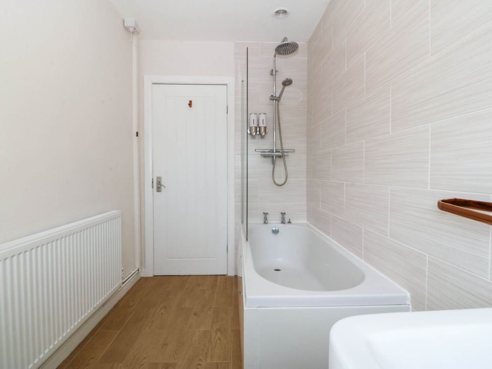 A bathroom with a bathtub and shower at Wilpol in Llanerchymedd