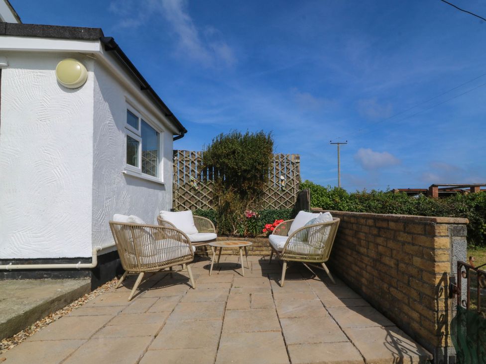 An outdoor patio with chairs and a table at Wilpol in Llanerchymedd