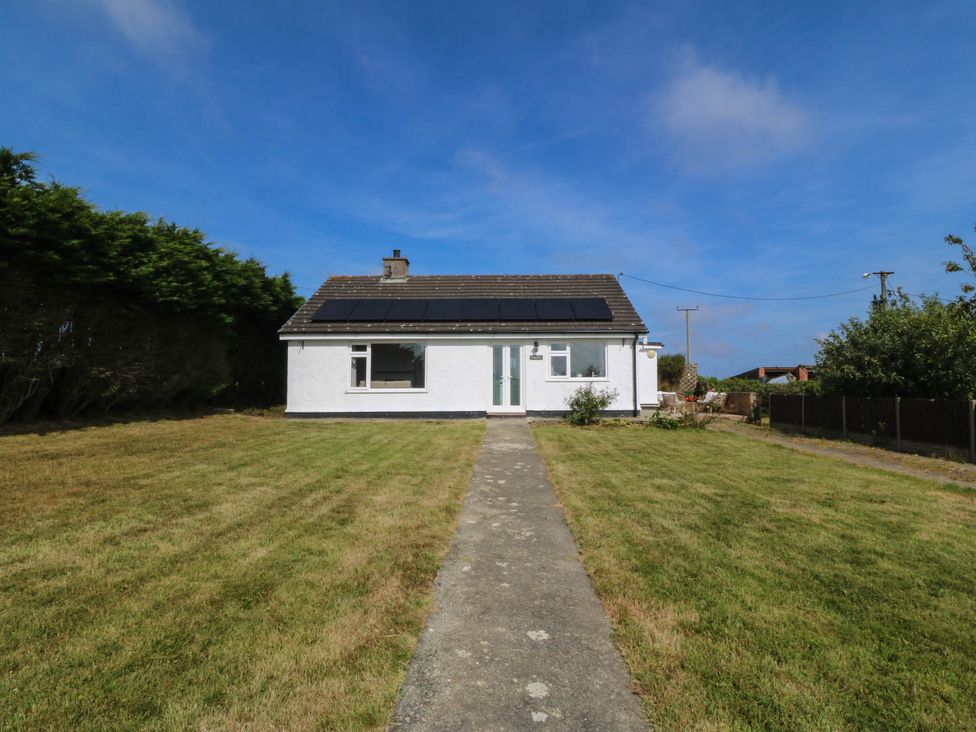 A house with solar panels and a path leading to it at Wilpol in Llanerchymedd
