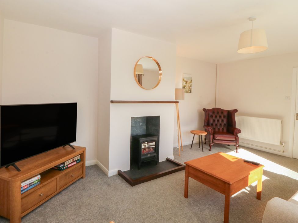 A living room with a fireplace and television at Wilpol in Llanerchymedd