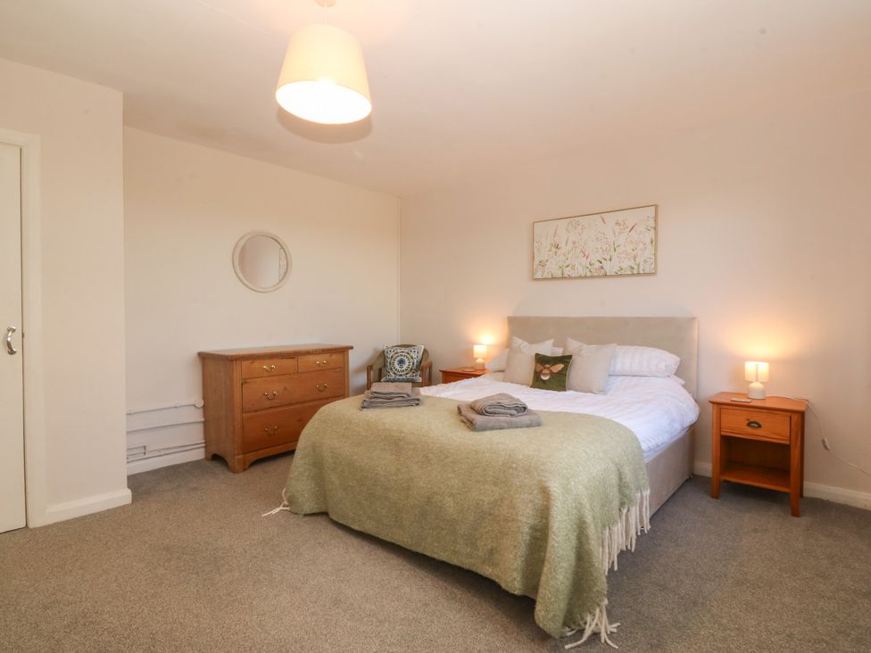 A bedroom with a bed and nightstands at Wilpol in Llanerchymedd