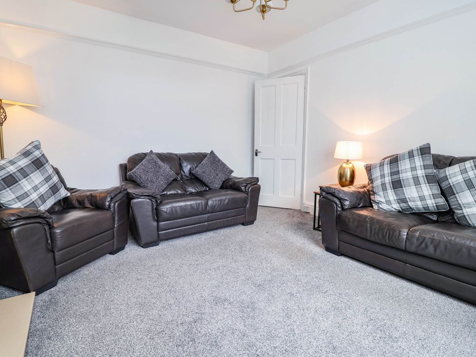 A living room with two sofas and a lamp at 29 Vale Road Ellesmere Port