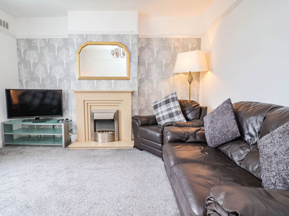 A living room with a sofa and TV at 29 Vale Road in Ellesmere Port