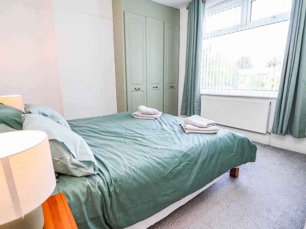 A bedroom with a bed and towels at 29 Vale Road in Ellesmere Port