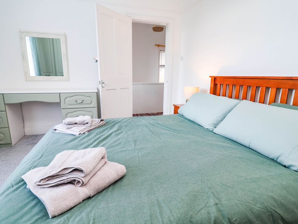 A bedroom with a bed and a desk at 29 Vale Road in Ellesmere Port