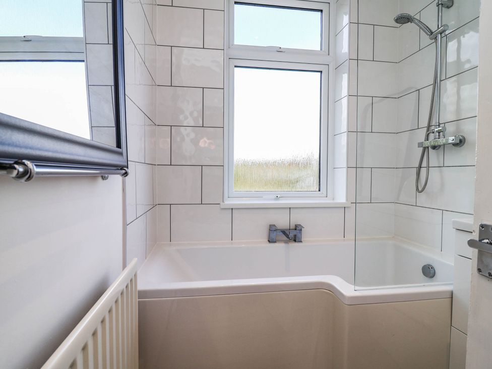 A bathroom featuring a bathtub and shower at 29 Vale Road in Ellesmere Port