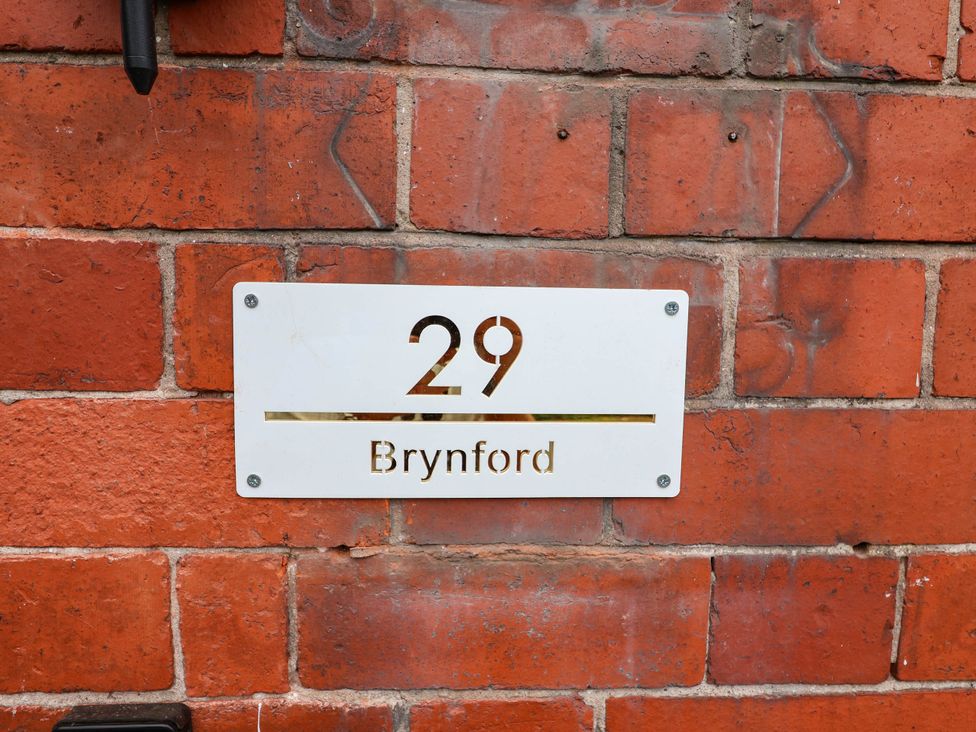 A house number sign on a brick wall at 29 Brynford