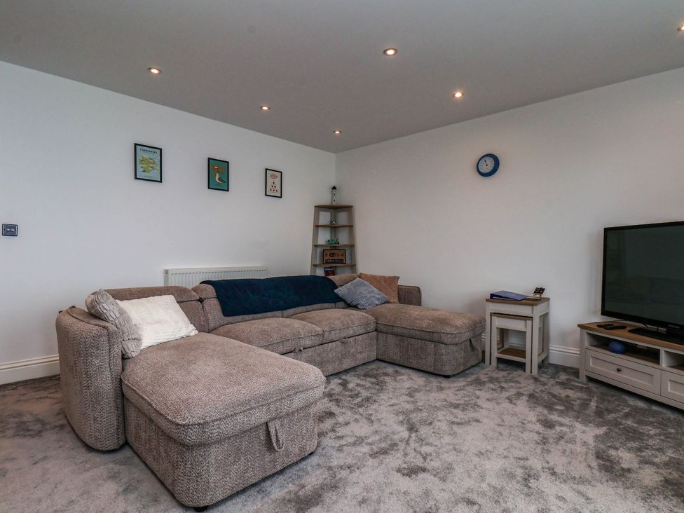 A living room with a sofa and television at The Gulls Rest 