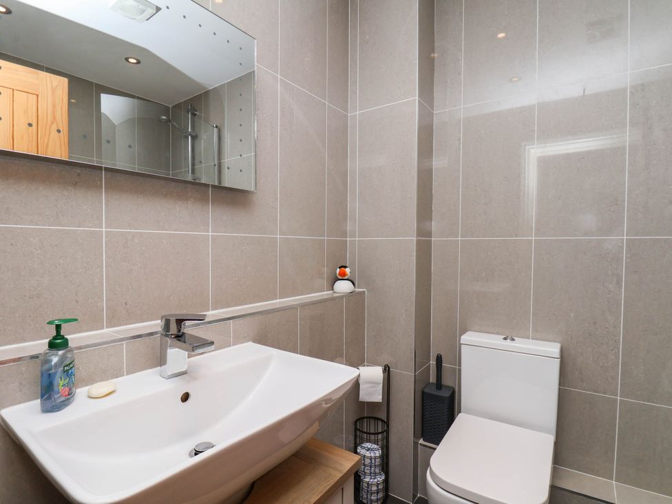 A bathroom with a sink, mirror and toilet at The Gulls Rest