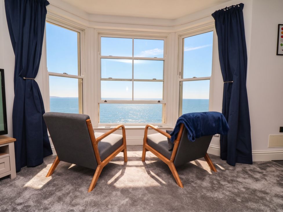 A living room with armchairs and a sea view at The Gulls Rest