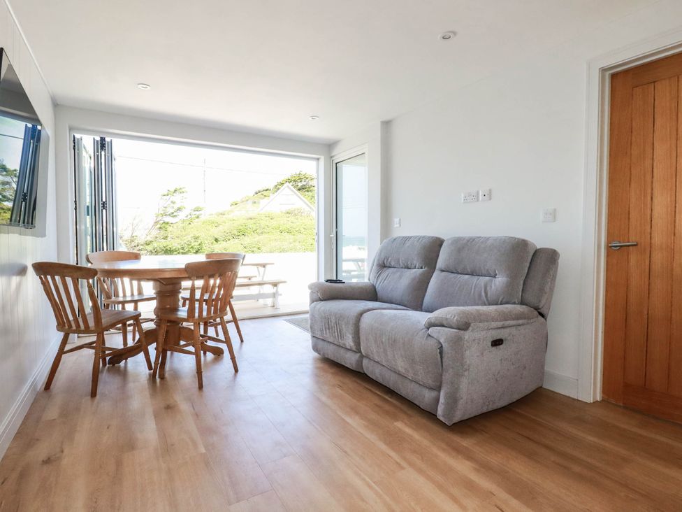 A living room with a sofa and dining table at 9 Tides Reach Wadebridge