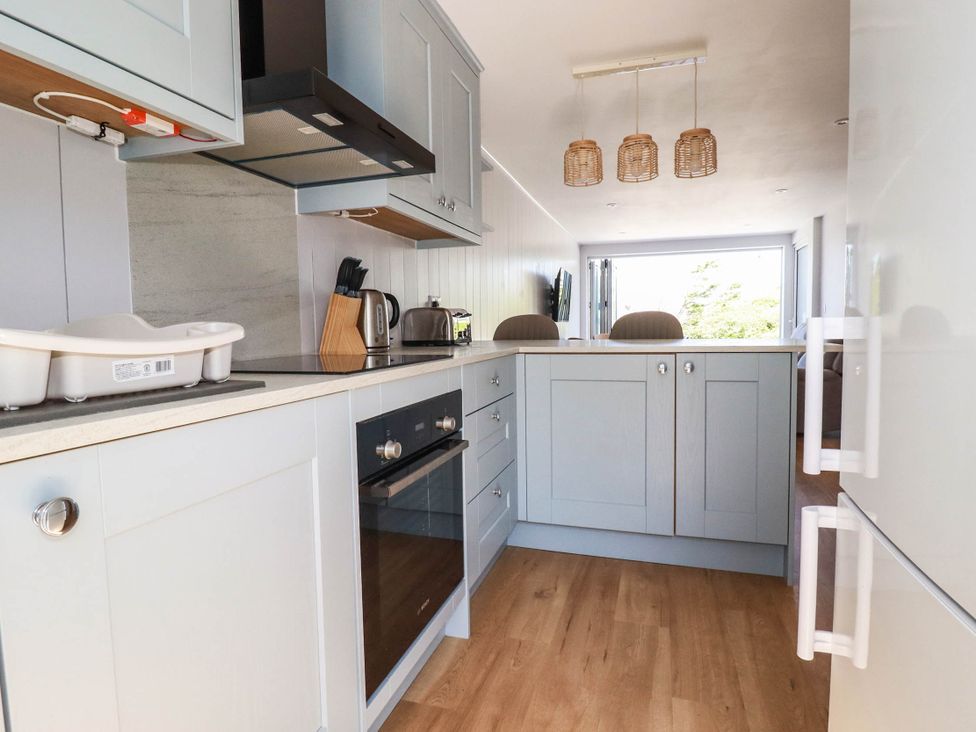 A kitchen with cabinets and appliances at 9 Tides Reach Wadebridge