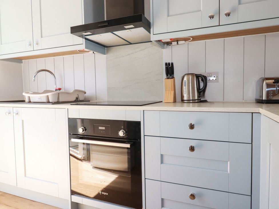 A kitchen with sink, kettle, toaster, and oven at 9 Tides Reach Wadebridge