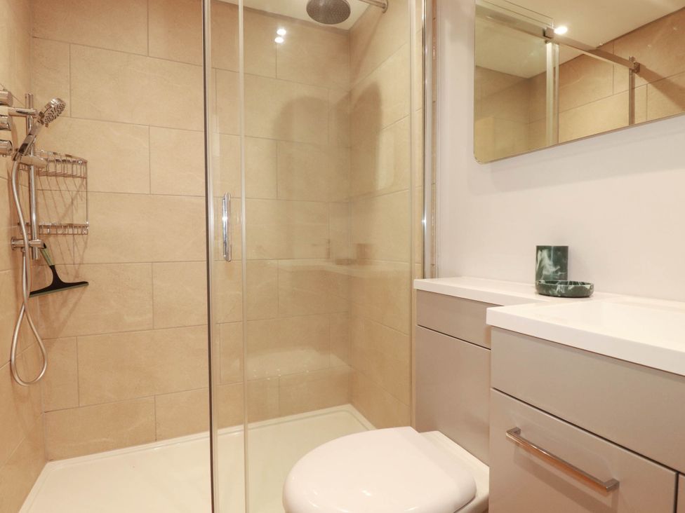 A bathroom with a shower, toilet, and sink at 9 Tides Reach in Wadebridge