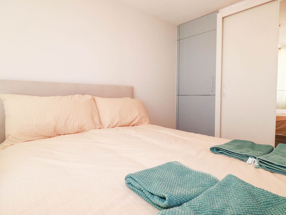 A bedroom with a bed and towels at 9 Tides Reach Wadebridge