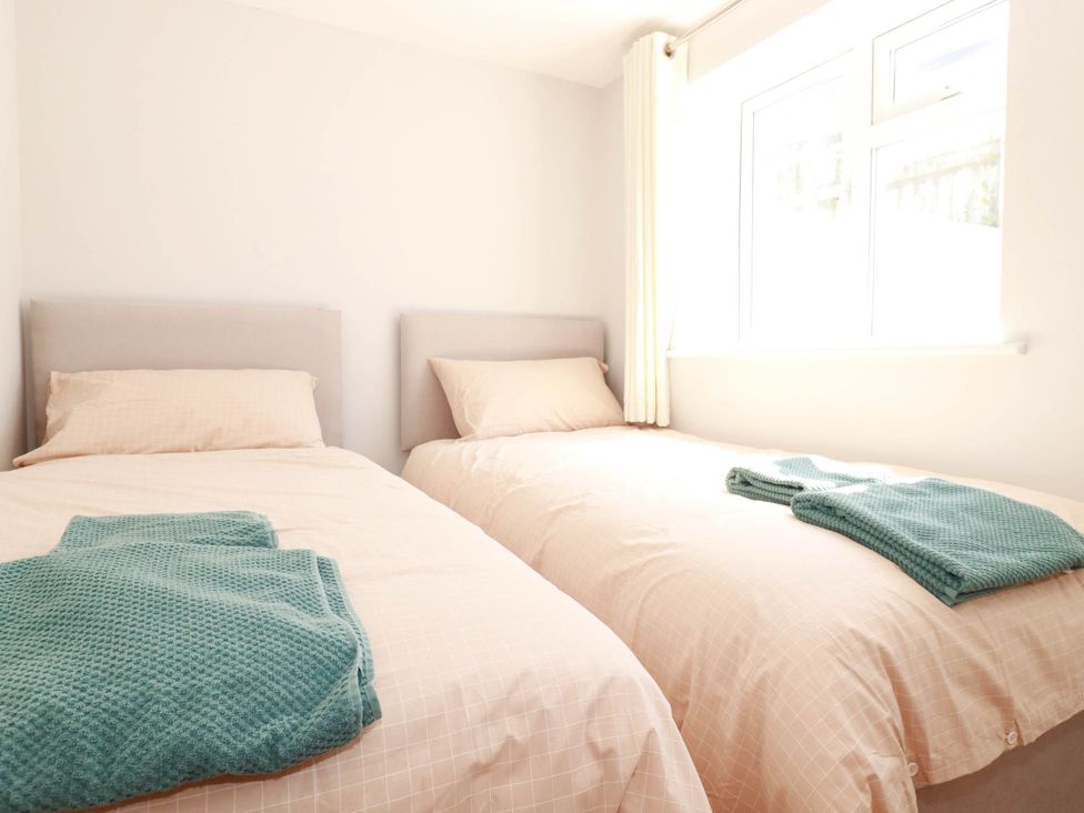 A bedroom with two beds and blankets at 9 Tides Reach Wadebridge