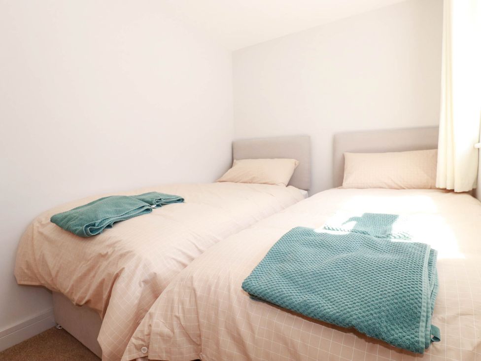 A bedroom with two single beds and blankets at 9 Tides Reach Wadebridge