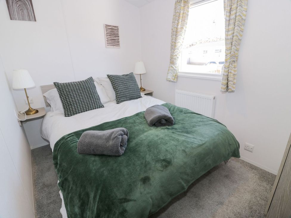 A bedroom with a bed and bedside lamps at Dunskey Way in Portpatrick