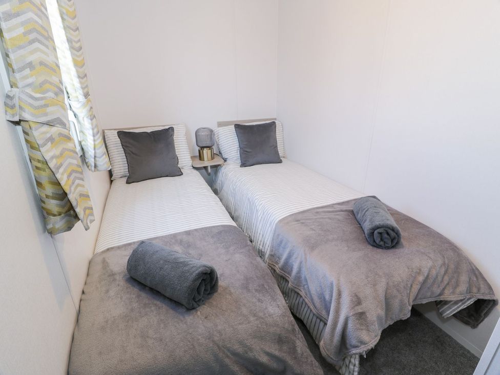 A bedroom with two beds and a lamp at Dunskey Way in Portpatrick