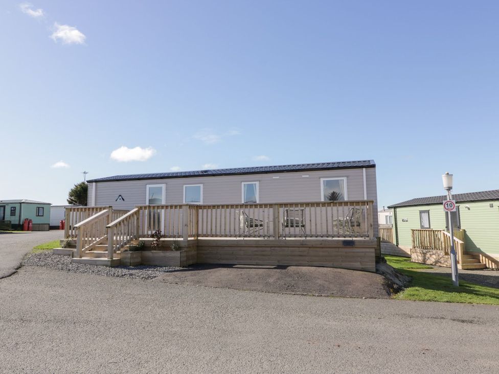 A mobile home with a deck and staircase at Dunskey Way in Portpatrick
