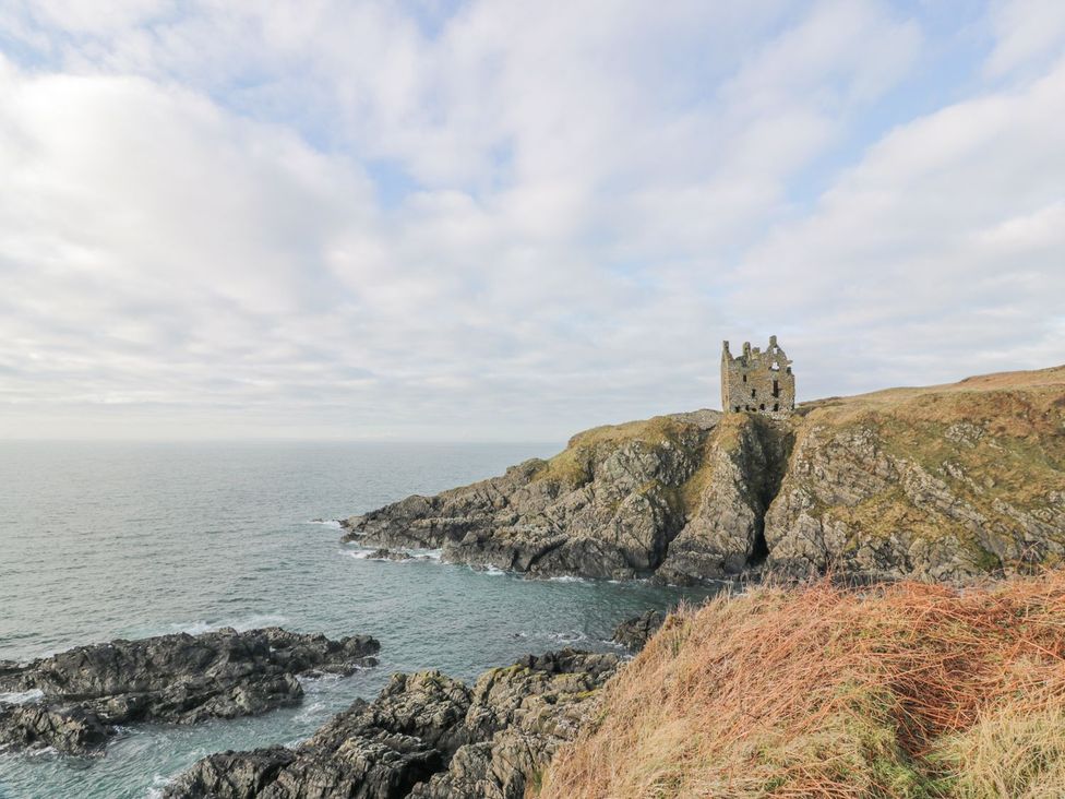 A view of castle ruins on a rocky coastline at Dunskey Way in Portpatrick
