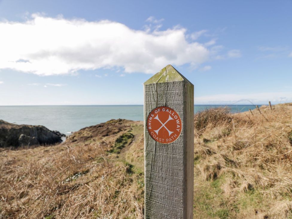 A signpost marking the Rhins of Galloway Coast Path by the sea at Dunskey Way in Portpatrick