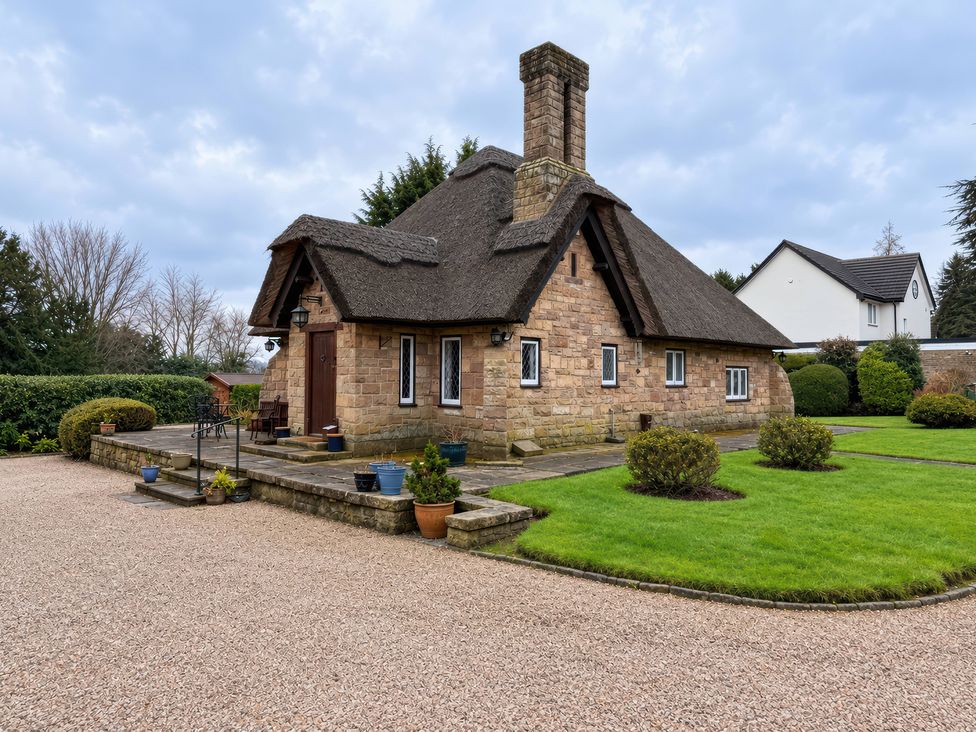 A house with a thatched roof and garden at Tudor Lodge near Belper
