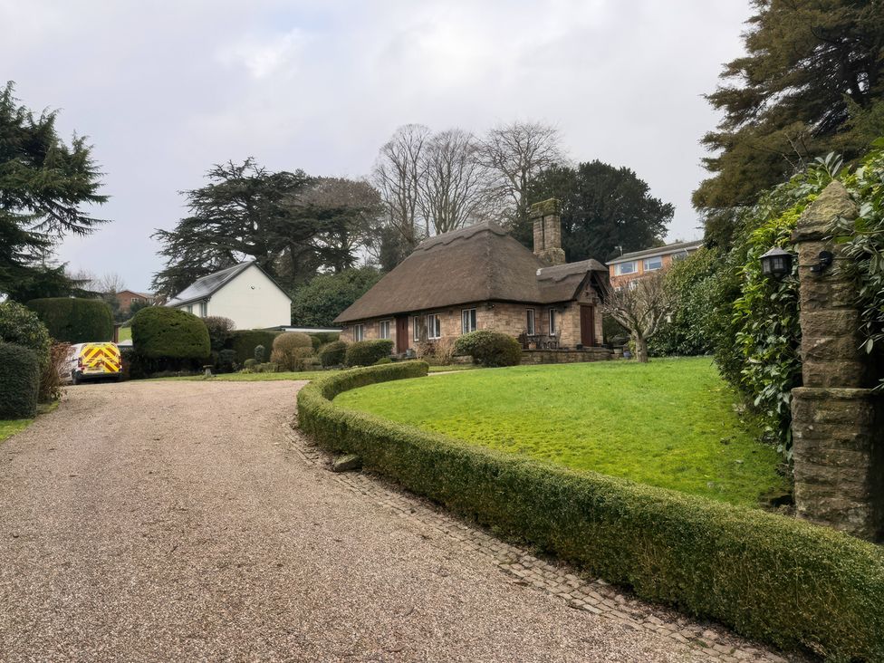 A house with a thatched roof and garden at Tudor Lodge near Belper