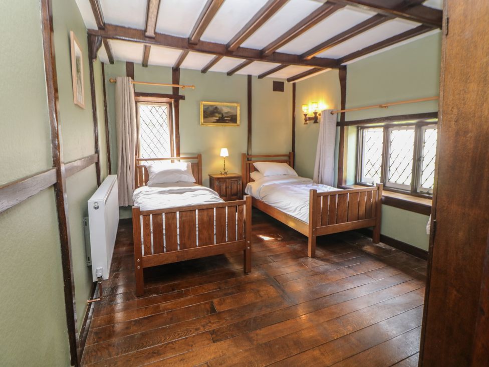 A bedroom with two beds and a nightstand at Tudor Lodge near Belper