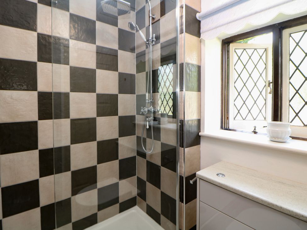 A shower area with tiles and a window at Tudor Lodge near Belper