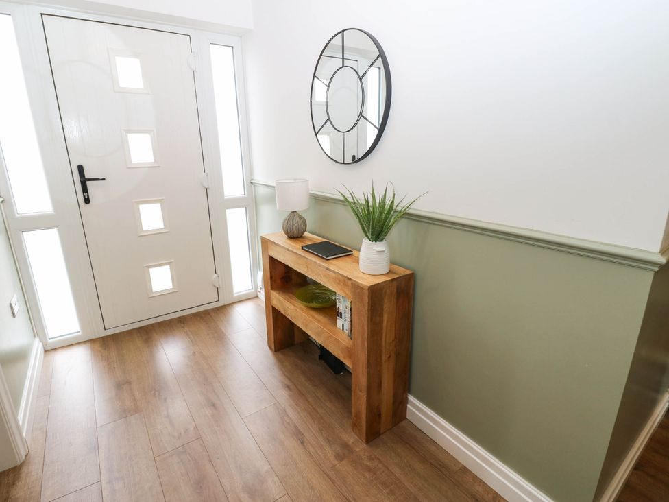 A hallway with a wooden table and a mirror at The Greenway in Darlington