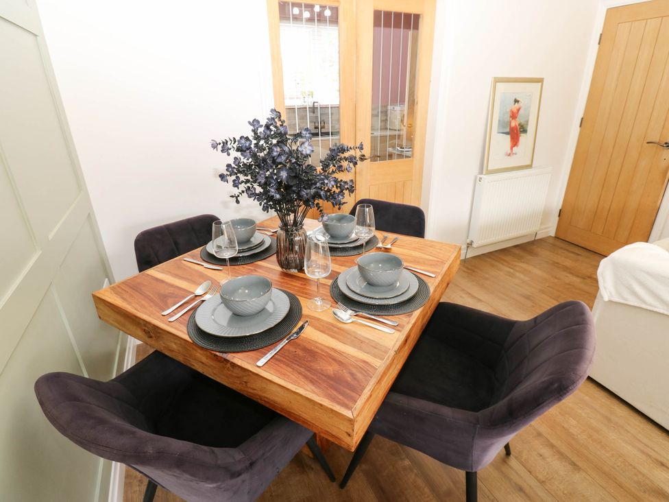A dining room with a wooden table set for four at The Greenway in Darlington