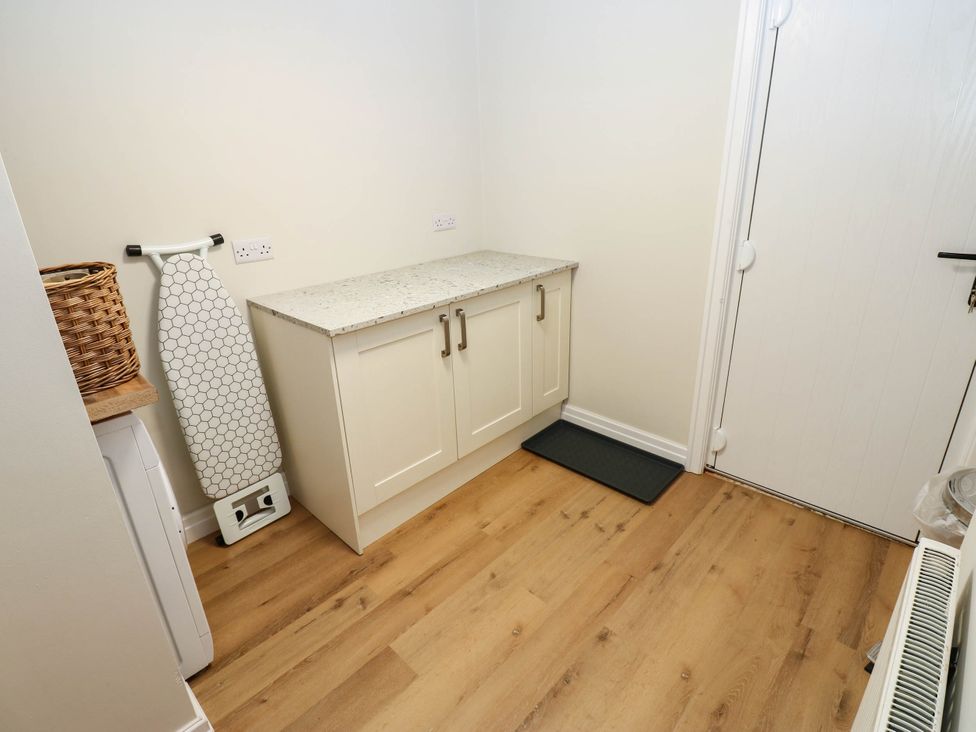 A laundry room with a washing machine and cupboard at The Greenway in Darlington