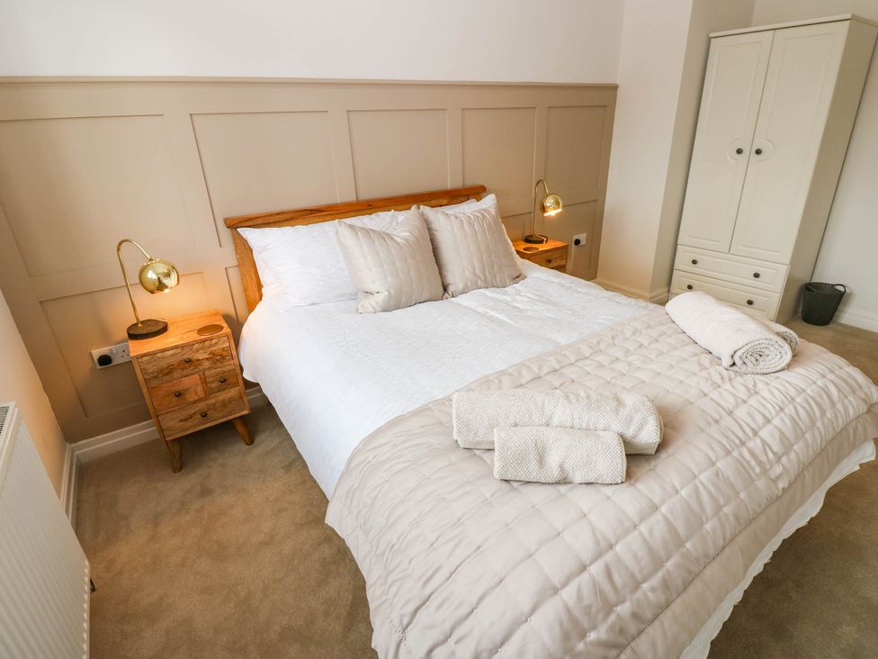 A bedroom with a bed, nightstands, and a wardrobe at The Greenway in Darlington