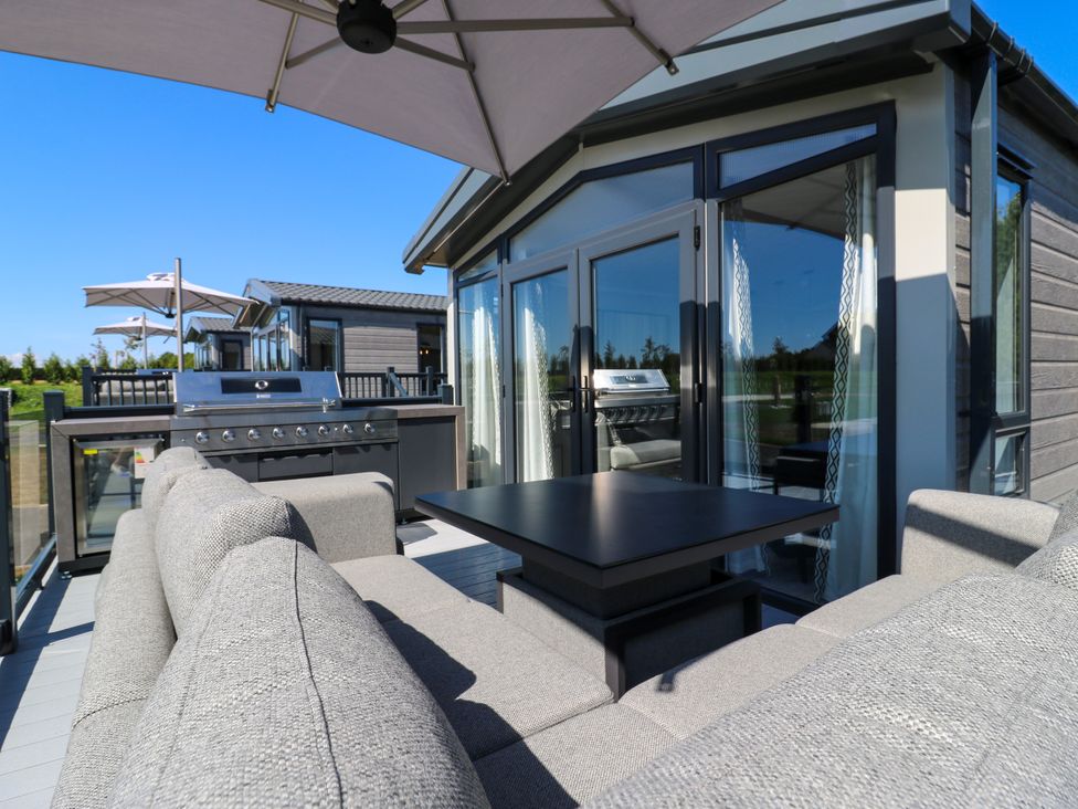 An outdoor seating area with a table and barbecue grill at Lakewood Plot 3 St. Osyth
